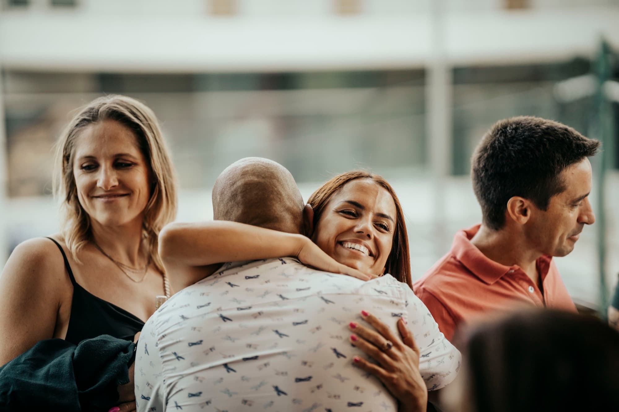 A guest hugging a friend across the table at Tapas y Copas